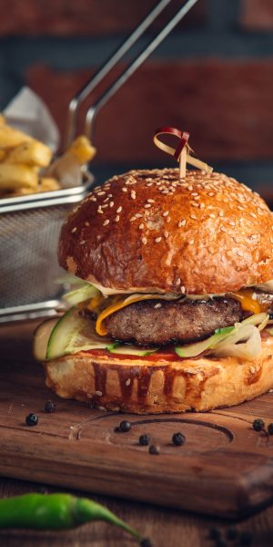 huge burger with fried meat and vegetables